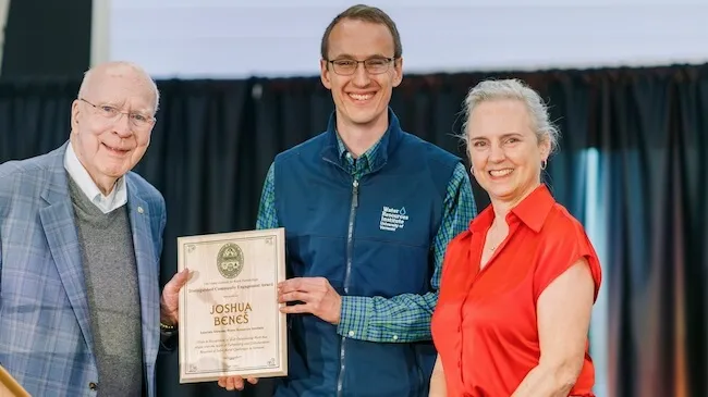 a man receives an award plaque