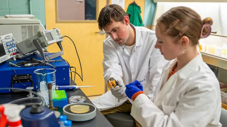 CEE Master's Student Cooper Petrie guides an undergraduate research student through a lab process