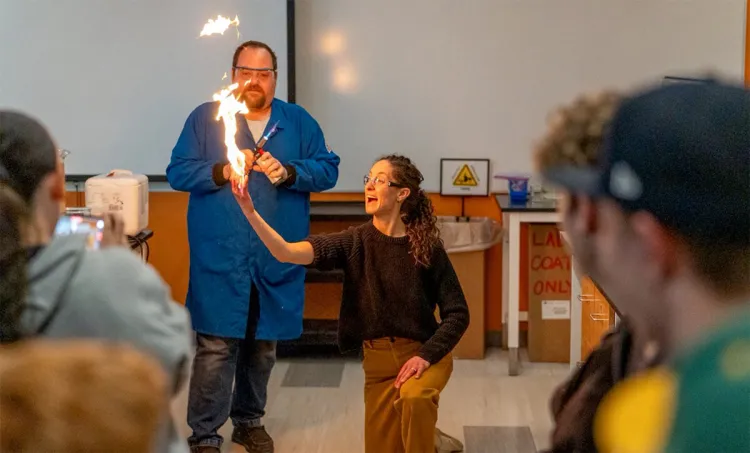 8th Grade Camels Hump teacher Anna Mildrum, with her hand on fire.
