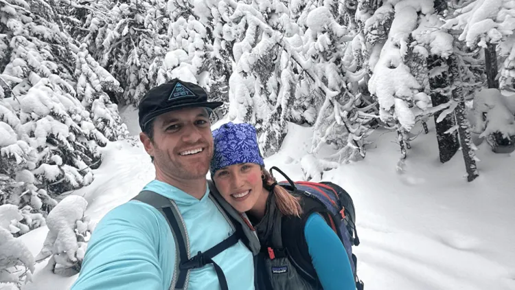 two people hugging outdoors in snowy woods