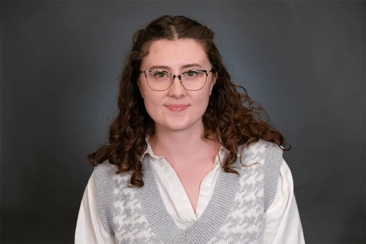 Person in a photo studio smiling at the camera.