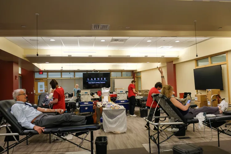 People in a room laying on chairs having blood drawn. 