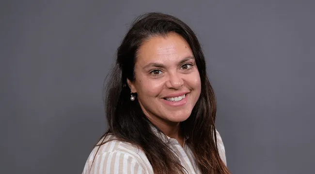 Person smiling at the camera inside a photo studio.