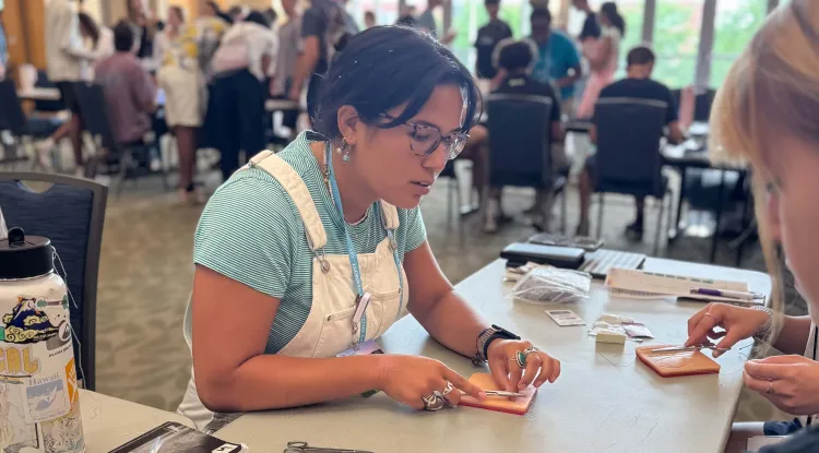 a group of people at a table practicing suturing