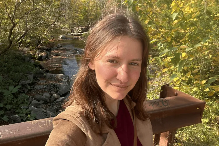 Person outside on a bridge smiling at the camera.