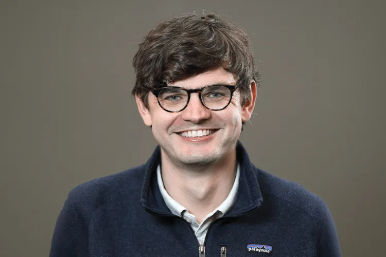 Person smiling at the camera inside a photo studio.