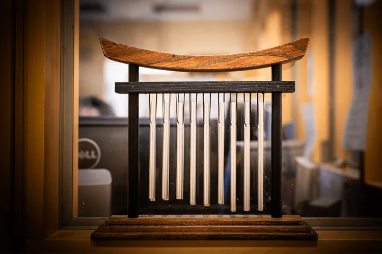 A windchime in front of a window. 