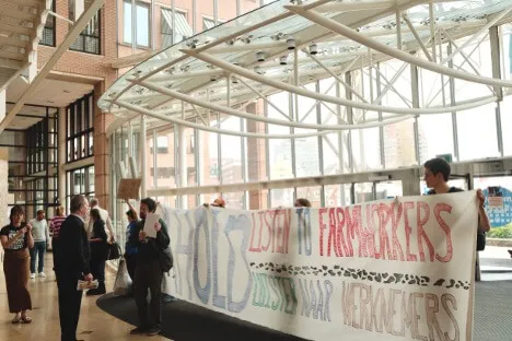 People standing in a glass atrium with a banner