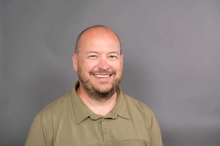 Person smiling at the camera inside a photo studio.