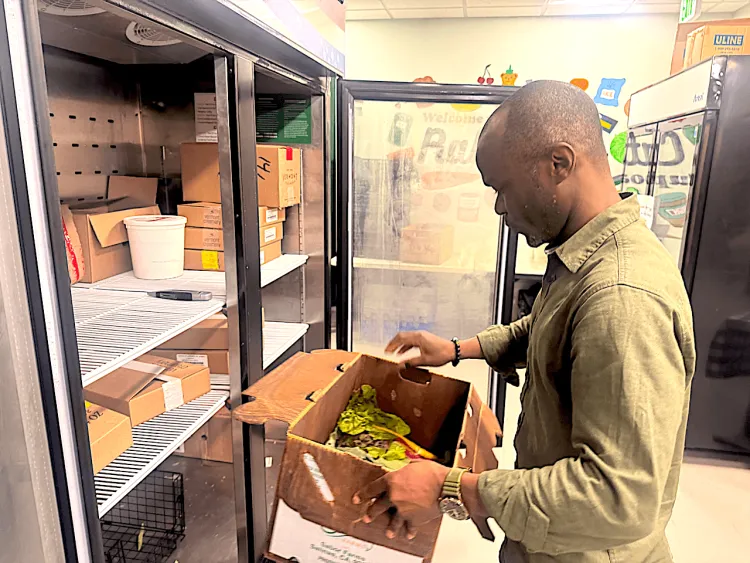 A man stocking the refrigerator in a food cupboard