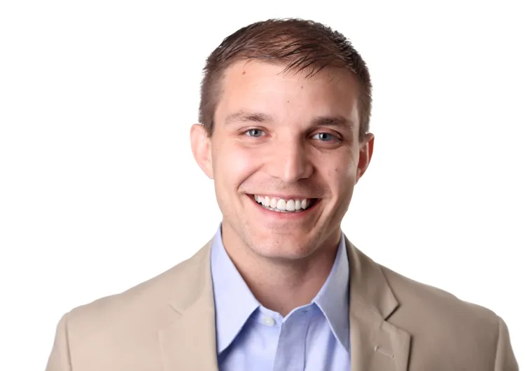 Person smiling at the camera inside a photo studio.