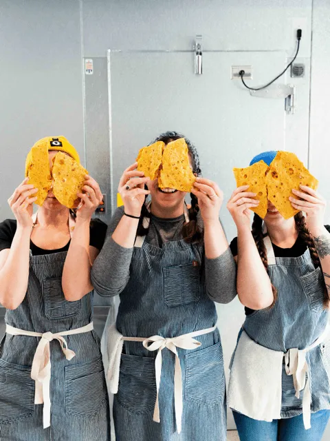 three women with waffle cones in front of their faces