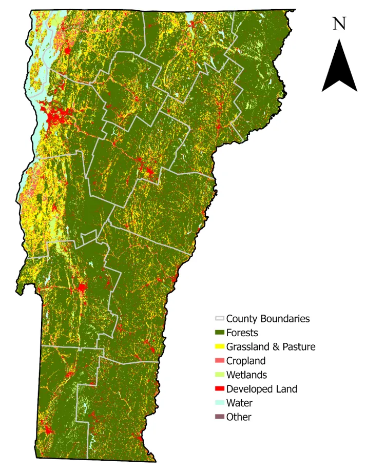 A map of Vermont divided by county, showing land use classifications for different categories: Forests, grassland and pasture, croplands, wetlands, developed lands, water, and other. Forest cover (dark green) is the dominant land use across the state, while grassland, pasture, and developed land (yellow and red) is more prominent in the Champlain Valley.