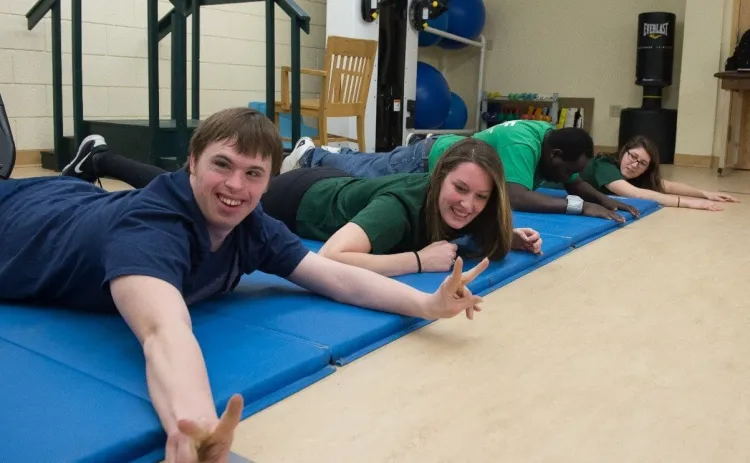 Exercise student volunteer with participant in Unified Fitness program