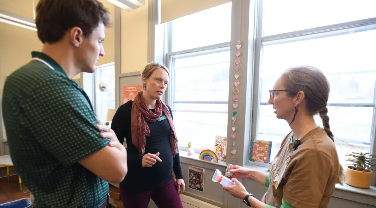 3 people talking, one a nurse holding asthma medication