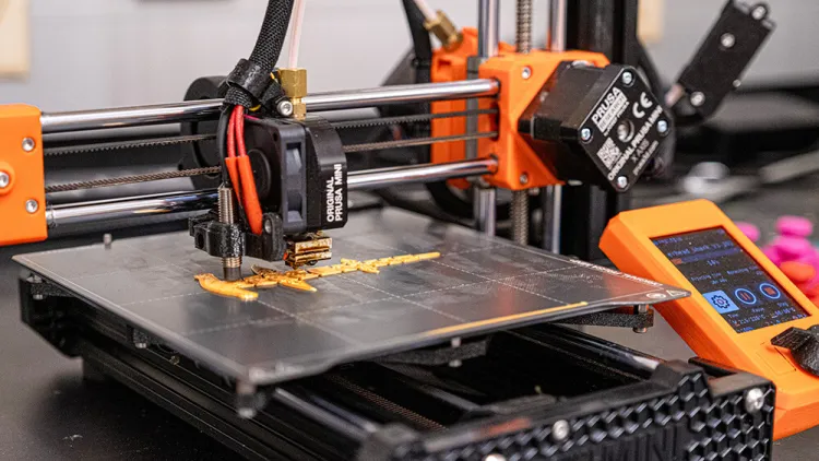 A view of a tabletop 3D printer starting to produce a project