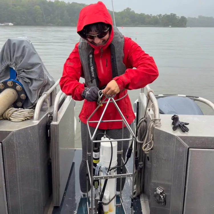 Liz pulling a buoy out of the water and onto the boat.
