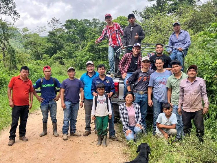 A group photo in front of a forested background. 