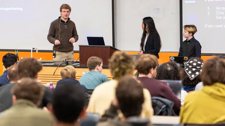 Henrik Van Tassell, Nina Braddock, and Lee Ericson speak to students before their hackathon time begins.
