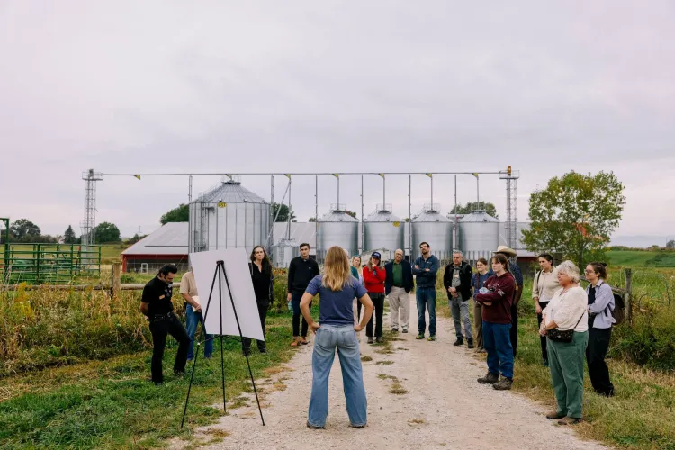 Sloane Selenis gives a poster presentation in front of a barn