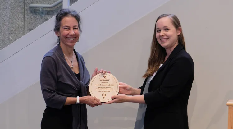 2 people holding an award plaque