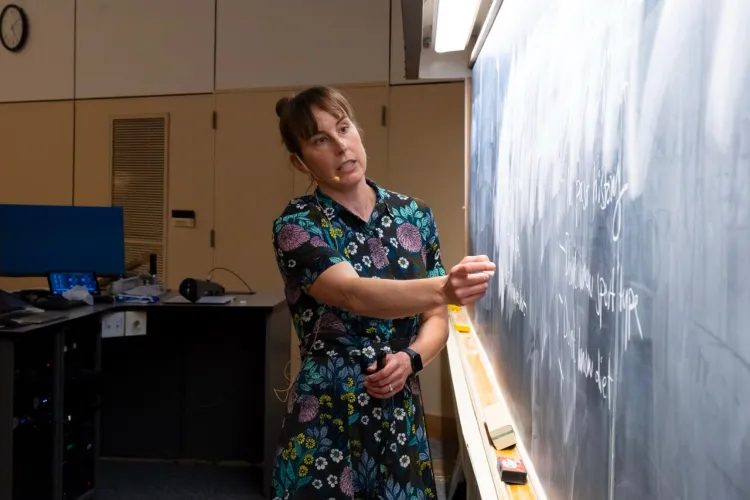 Faculty at the chalkboard writing