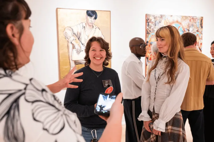 Three visitors talking in the gallery
