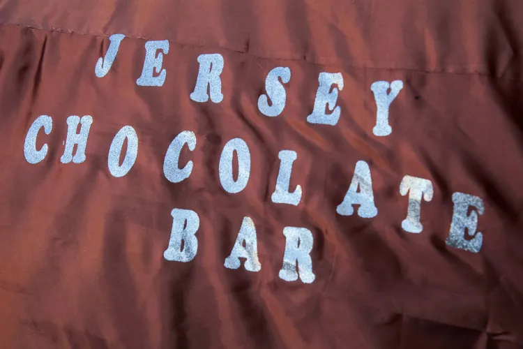 Silver letters spelling "Jersey Chocolate Bar" on a shiny brown blanket.