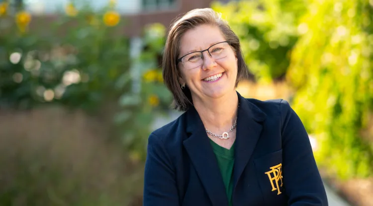 a person in a blazer posing outdoors