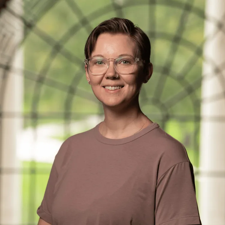A photo of Meg Jones standing before a large window.