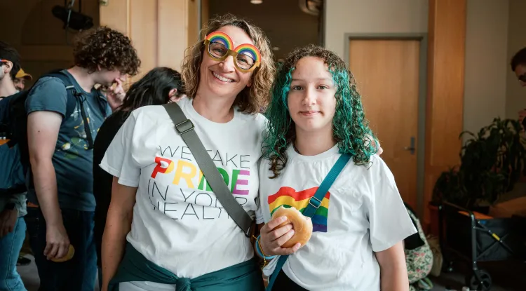 Two colorfully dressed people with other people in the background
