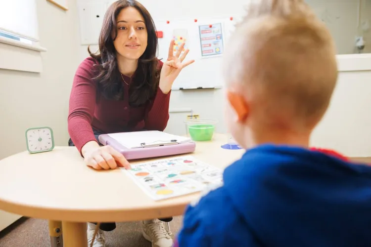 Student working with young SLP client in treatment room