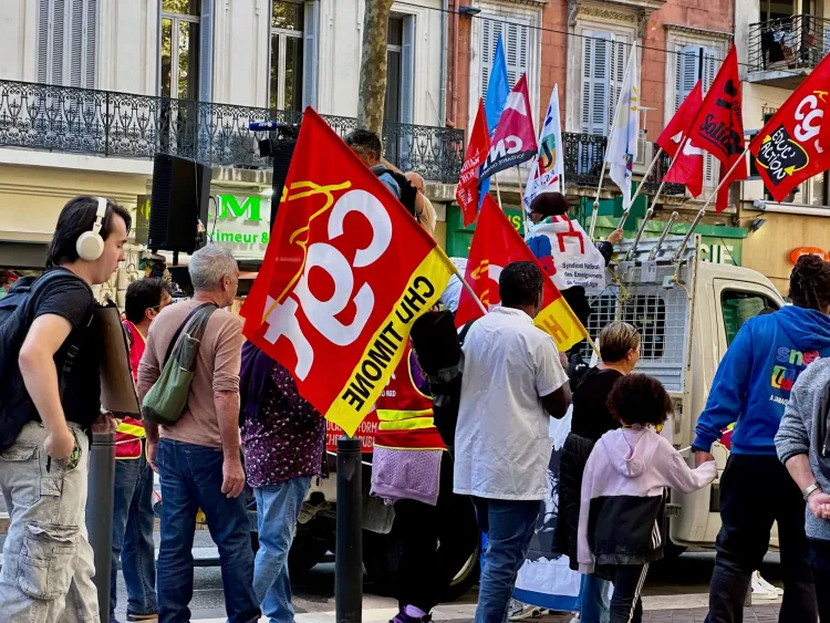 Protestors walk down the street holding flags