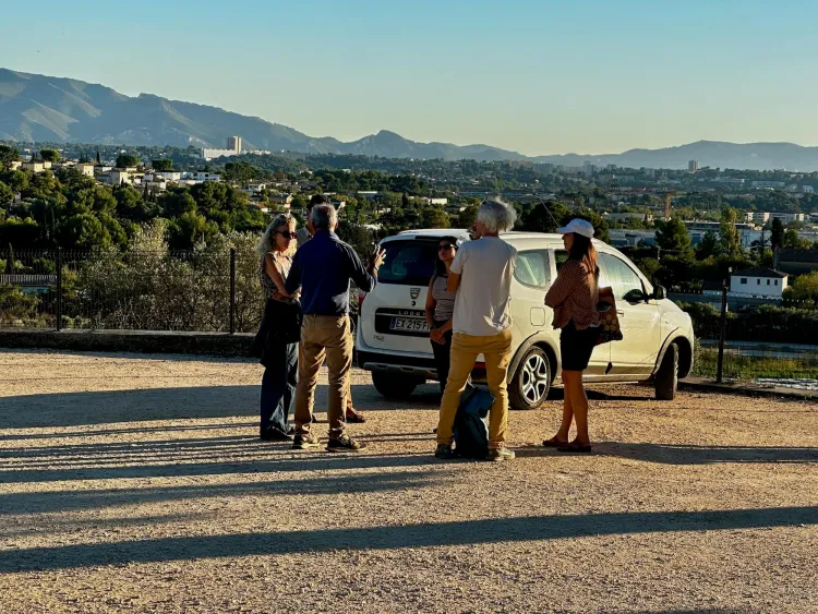 People stand in a circle outside with mountains in a background