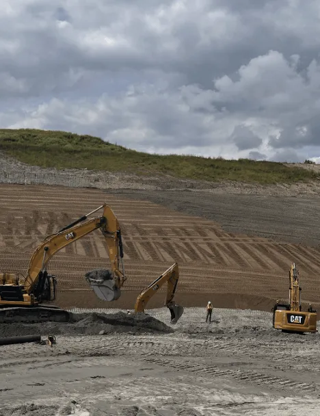 Diggers scour the landscape of gravel and dirt