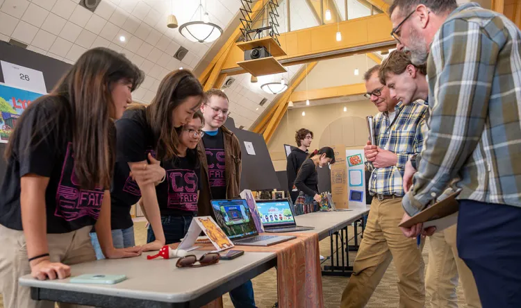 A group of students share their computer science fair project with faculty judges
