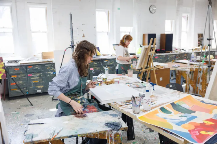 Students painting in a bright art studio.