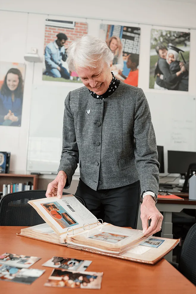 Katie Shepherd in her office looking at a photo album
