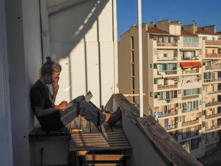 Woman sits on an apartment balcony