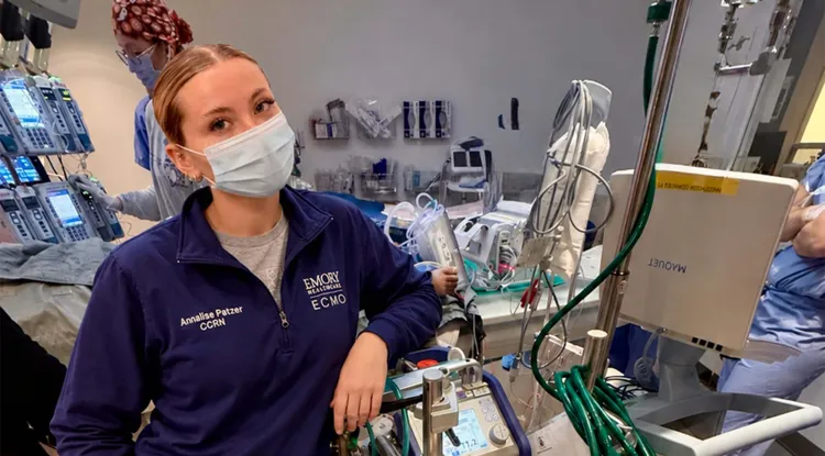 a person in a room full of complicated-looking medical equipment and paraphernalia 
