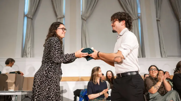 Nursing student receives a green vest from a faculty member