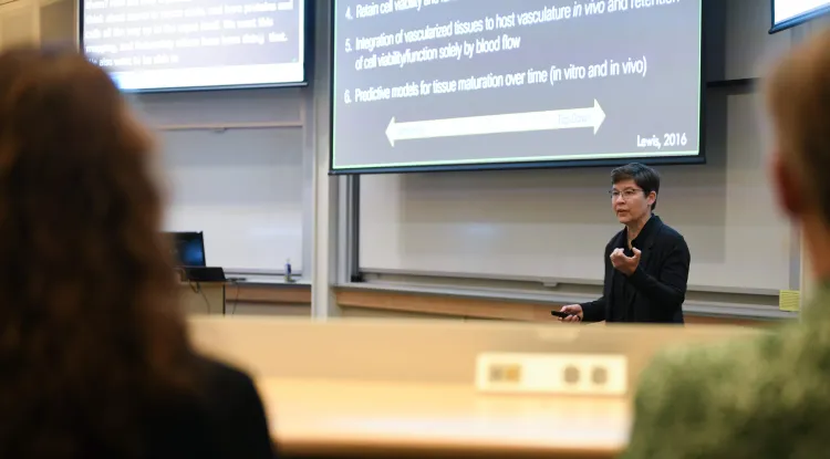 a person making a presentation in front of large screens