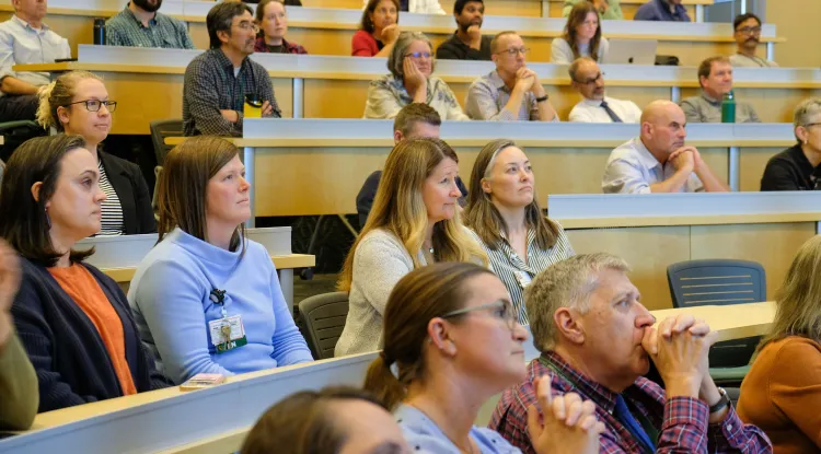 an audience in multitiered seats listening to a lecture
