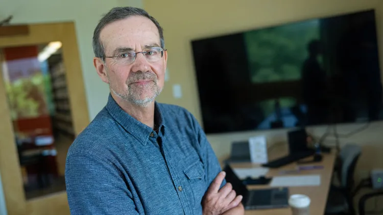 Richard Watts stands in his office between phone calls 