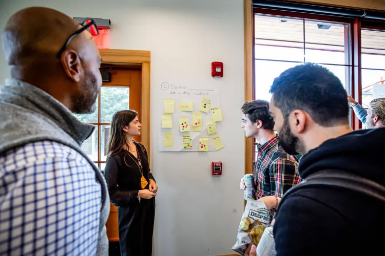 Sustainable Innovation MBA students from the Grossman School of Business use sticky notes and poster board in an idea generating exercise