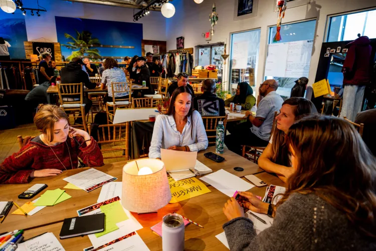 Attendees to the See Change conference brainstorm marketing ideas around a table.