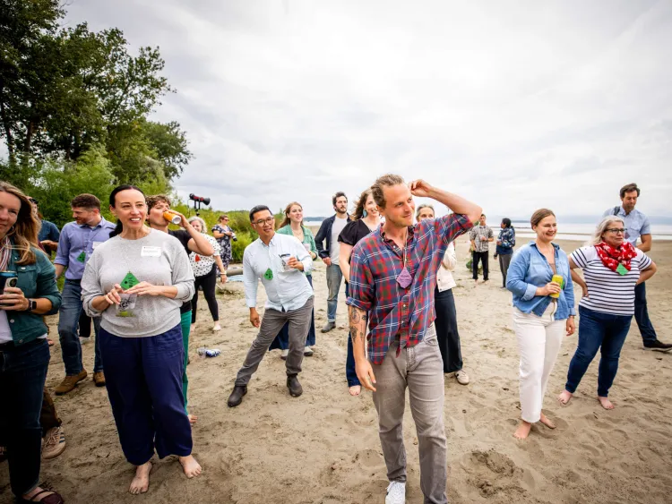 Sustainable Innovation MBA students and faculty join other attendees outside on a beach at the See Change conference.