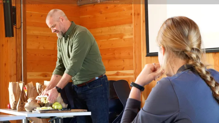 Faculty member cuts up apples to share in a class
