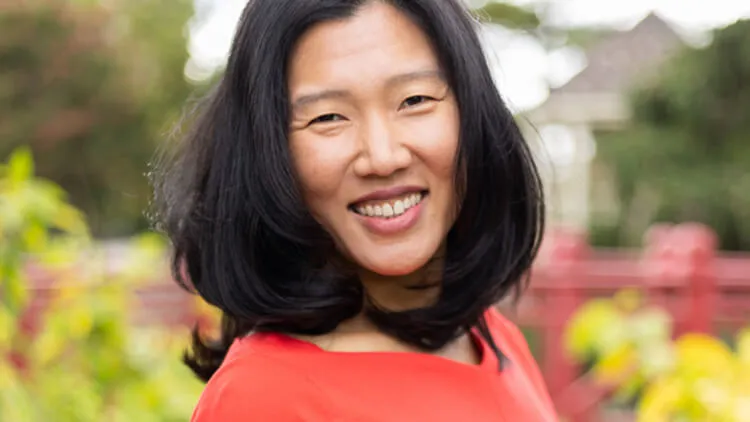 Portrait of Seugmi Laura Cho smiling outdoors.
