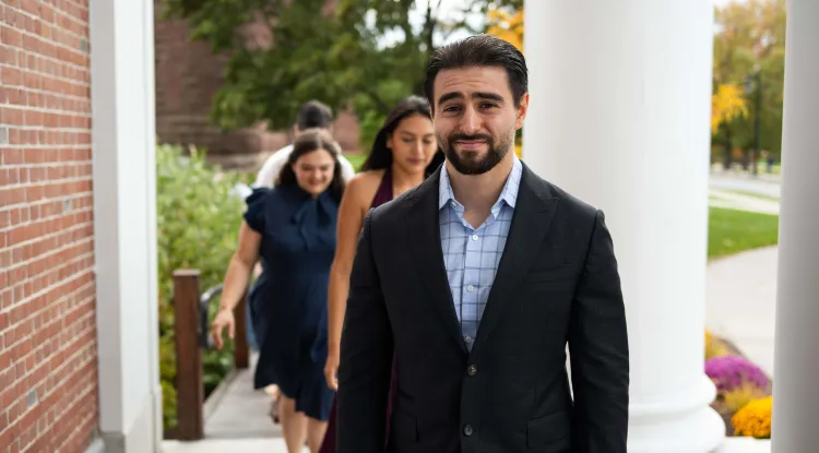 a person in a blazer with a line of people following behind